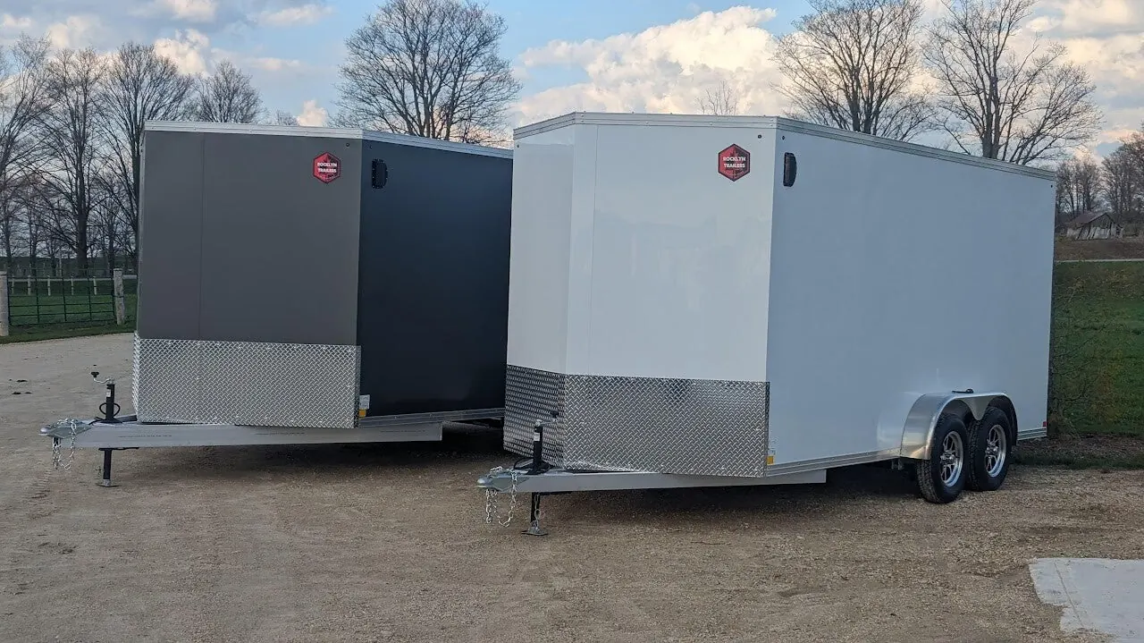 Black enclosed trailer with roof ladder and diamond-plate stone guard